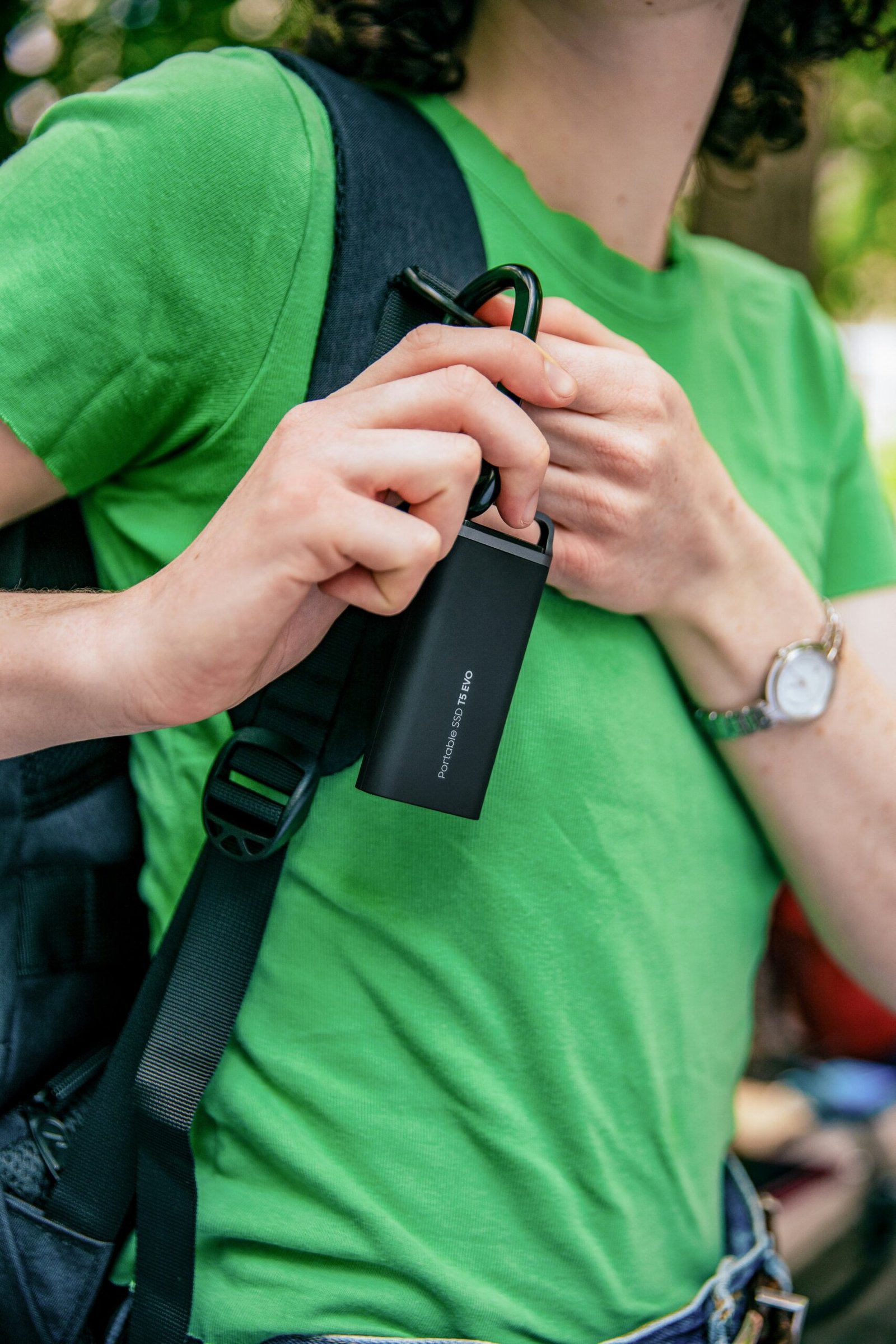 A man in a green shirt holding a cell phone